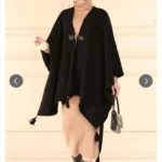 Svart poncho dam i modest design framifrån Elegant svart poncho med lös passform och mjukt fall Modest poncho i svart stylad med slöja