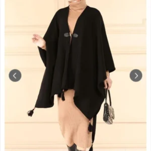 Svart poncho dam i modest design framifrån Elegant svart poncho med lös passform och mjukt fall Modest poncho i svart stylad med slöja