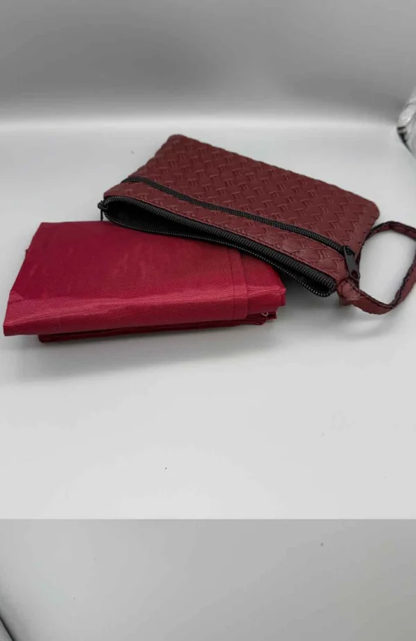 Resebönematta med läderväska i röd färg Detaljbild på mjuk bönematta och elegant läderväska Kompakt och bärbar bönematta för resor